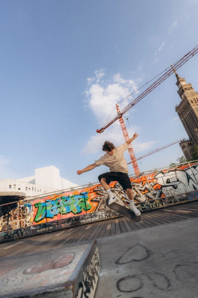 Skater w koszulce Miejska Fala w skateparku, w tle Pałac Kultury