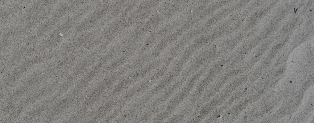 Drobny piasek na plaży z falistym wzorem odciśniętym przez wiatr